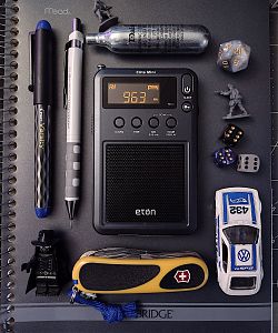 EDC photo of radio, pen & pencil, pocketknife, dice, toy soldiers