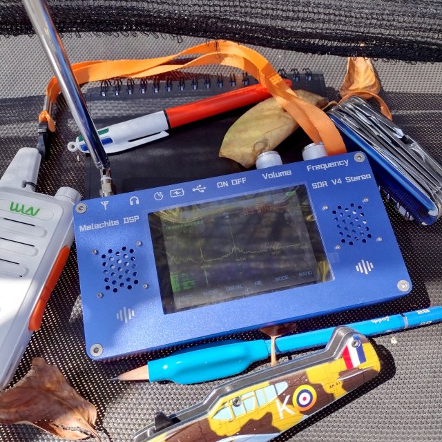 EDC photo of a radio and some pocket gear like a walkie talkie